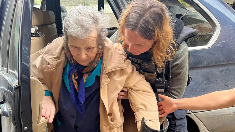 Anna Elsbern, Gründerin der NGO Universal Aid Ukraine, hilft einer Ukrainerin, eine Gefahrenzone im Kriegsgebiet zu verlassen.
