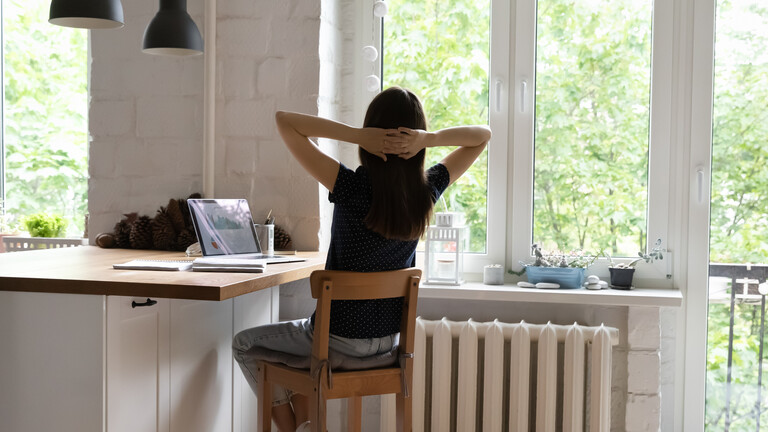 Person von hinten mit langen Haaren am Küchenschreibtisch