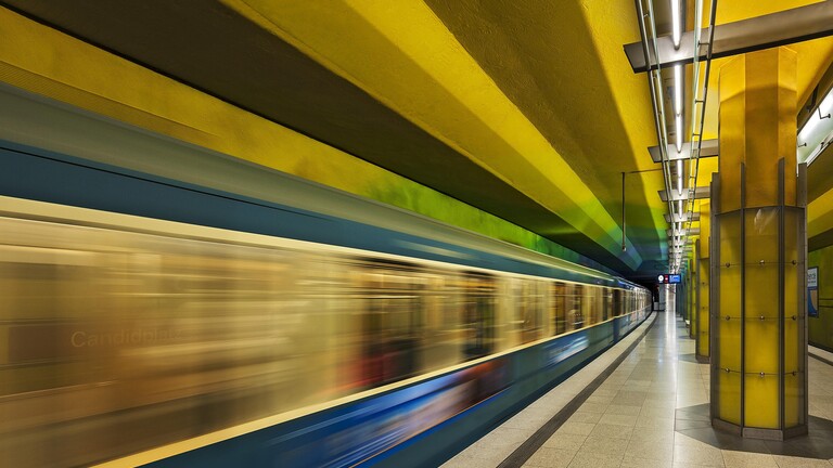 Eine Münchener U-Bahn rauscht durch einen U-Bahnhof