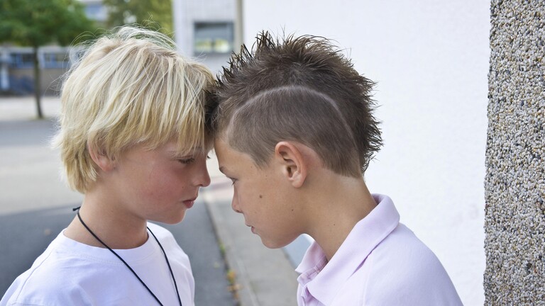 Zwei Jungs streiten sich auf dem Schulhof