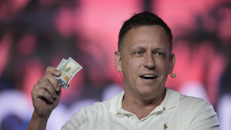 Der US-amerikanische Investor Peter Thiel hält mehrere Dollar-Scheine in der Hand
