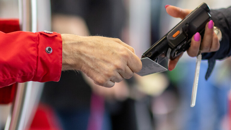 Eine Kontrolleurin kontrolliert ein Ticket