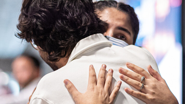 Menschen aus Afghanistan, die zuvor mit einem Flugzeug auf dem Flughafen Hannover gelandet sind, umarmen sich