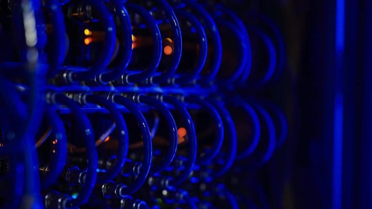 Computerkabel in Serverzentrum, rote Signalleuchten, blaues Neonlicht