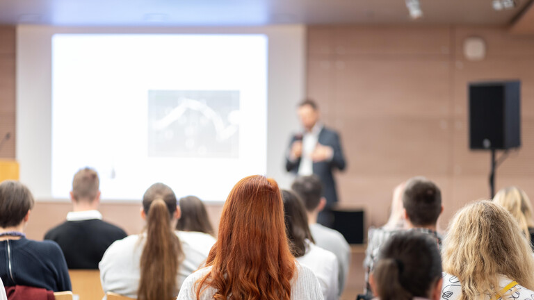 Menschen sitzen bei einem Vortrag