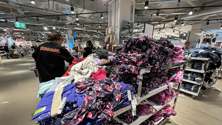 Massenhaft billige Kleidungsstücke stapeln sich in der Primark Filiale in München.