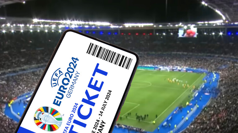 Fotomontage: Ein Ticket für die UEFA Euro 2024 Fußballeuropameisterschaft ist auf einem Handy und im Hintergrund ist ein volles Fußballstadion zu sehen