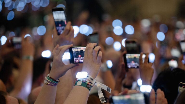 Zuschauer filmen während des Konzerts von Sängerin Taylor Swift am 17.7.2024 in der Veltins-Arena mit ihren Smartphones.