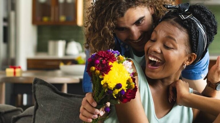 Ein Mann überrascht eine Frau mit Blumen