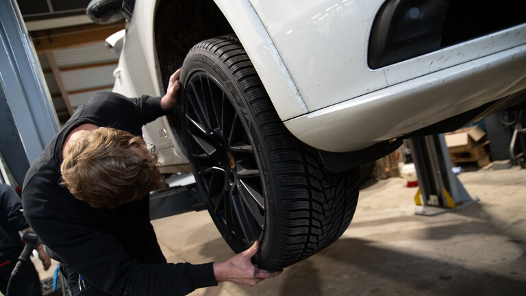 Mechatroniker wechselt Autoreifen