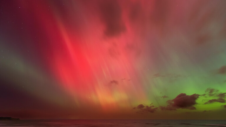 Helles Polarlicht (Aurora borealis) mit intensiven roten und grünen Farben über der Ostsee bei Gremersdorf, SH am 11. Oktober. 2024