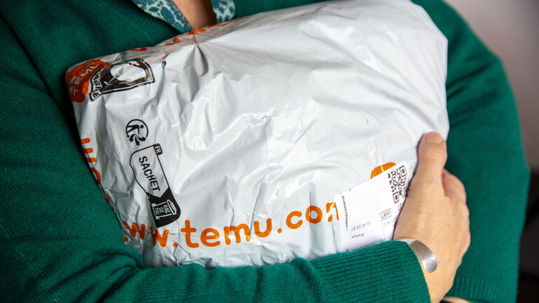 Eine Frau hält ein Paket von Temu