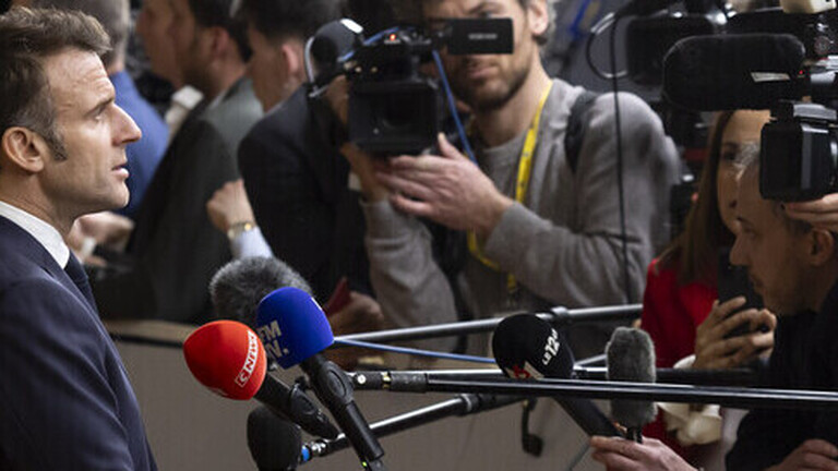 Emmanuel Macron gibt ein Pressestatement, vor ihm Kameras und Mikrofone