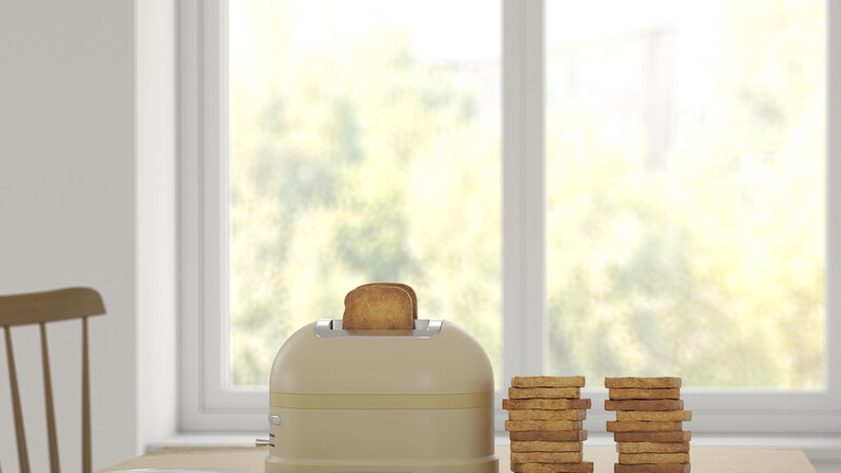 Toaster mit Toastbrot steht auf einem Tisch, daneben liegen zwei Stapel Toastbrot