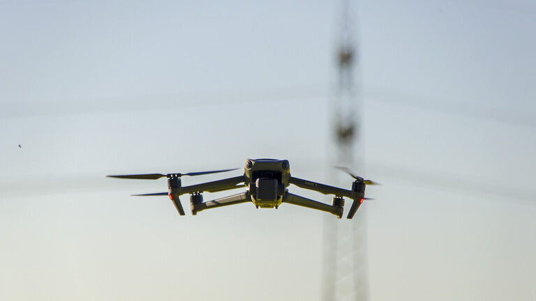 14.05.2025, Bad Woerishofen im Unterallgaeu. Drohne fliegt am Himmel, hinten ein Hochspannungsmast.
