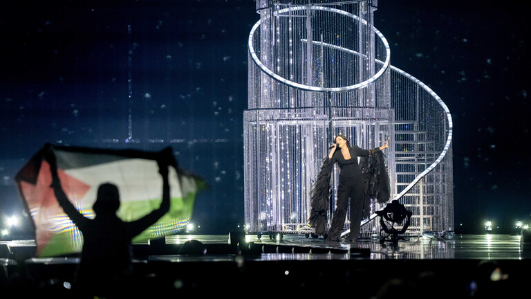 Ein Zuschauer hält eine palästinensische Flagge hoch, während Yuval Raphael bei der Generalprobe für das zweite Halbfinale des Eurovision Song Contests für Israel singt.