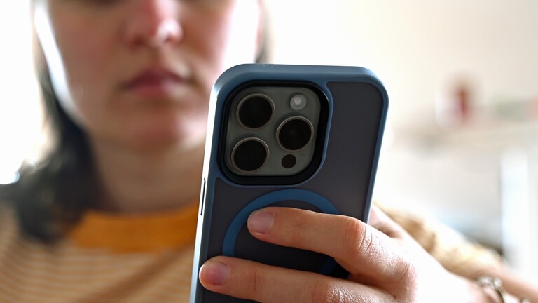 Eine junge Frau schaut auf ihr Smartphone