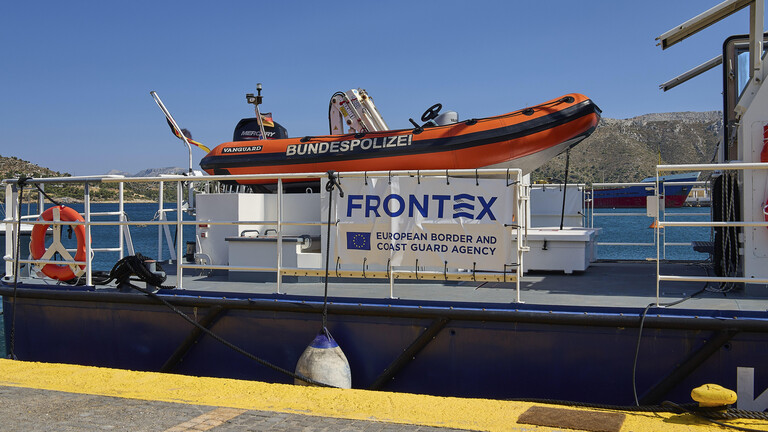 Frontex-Küstenwachtboot am Dock mit orangefarbenem Schlauchboot, auf dem Bundespolizei steht (Griechenland, 14.06.2025)