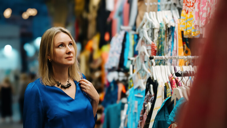 Eine Frau schaut sehnsüchtig auf Kleidung