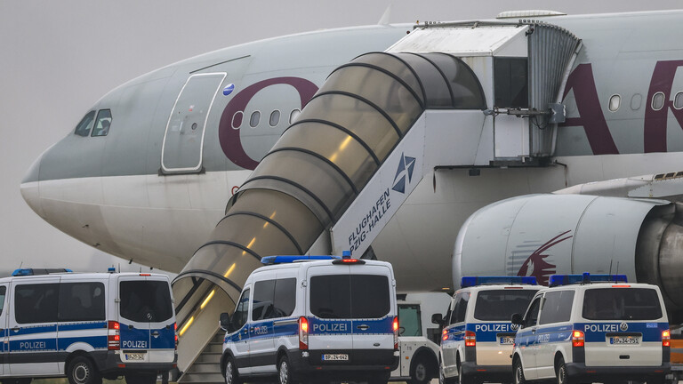 Polizeifahrzeuge stehen vor einem Flugzeug der Qatar Airways auf dem Flughafen Leipzig/Halle (18.07.2025)