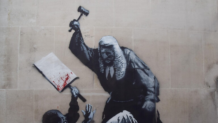 Das neueste Graffiti von Streetart-Künstler Banksy zeigt am Royal Courts of Justice einen Richter mit Perücke und Robe, der mit einem Hammer auf einen Menschen einschlägt.