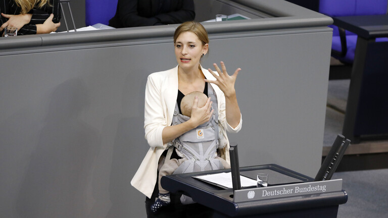 Hanna Steinmüller (Grüne) hält mit Baby in der Trage eine Rede im Bundestag (Berlin, 23.09.2025)
