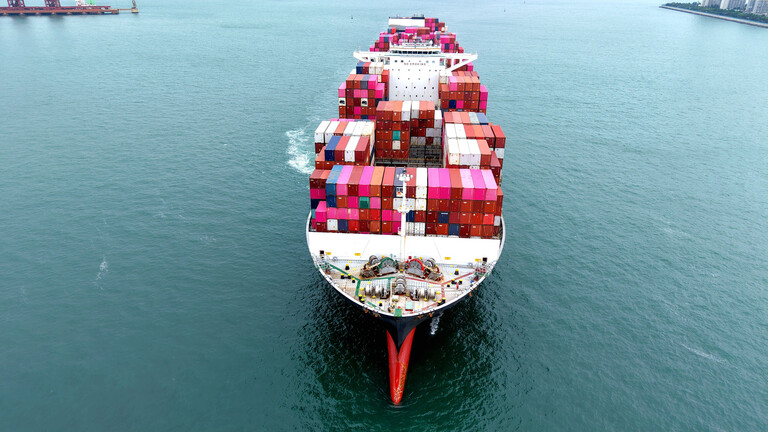 Luftaufnahme eines vollbeladenen Containerschiffs