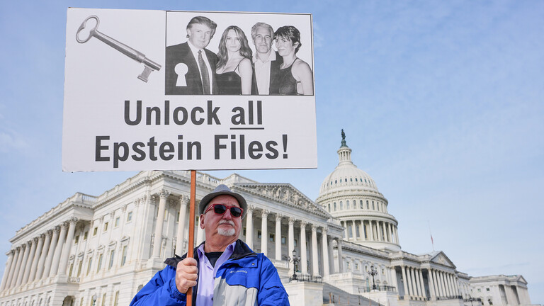 Gary Rush, College Park, MD, holds a sign before a news conference on the Epstein files in front of the Capitol, Tuesday, Nov. 18, 2025, in Washington. (AP Photo/Mariam Zuhaib)