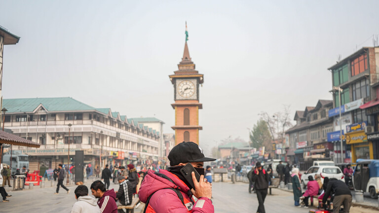Ein telefonierender Mann in der Nähe eines Uhrentursm am 2. Dezember 2025 in Srinagar im im nordindischen Unionsterritorium Jammu und Kashmir