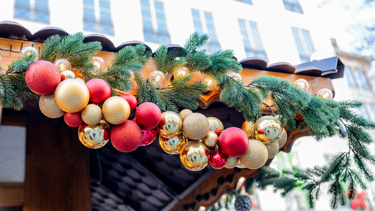 Weihnachtskugeln als Dekoration an einem Stand auf dem Münchner Christkindlmarkt.