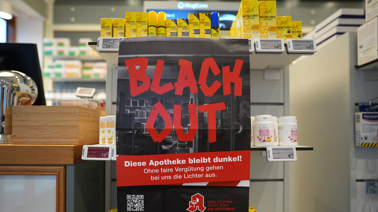Ein Plakat mit der Aufschrift "Blackout" hängt am Tresen in einer Apotheke (17.12.2025)