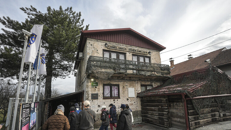 Menschen stehen vor dem "Tunnel der Hoffnung", der während der Belagerung von Sarajevo 1992–1995 errichtet wurde und eine entscheidende Lebensader zwischen der belagerten Stadt und der Außenwelt darstellte (20.02.2026, Bosnien und Herzegowina)