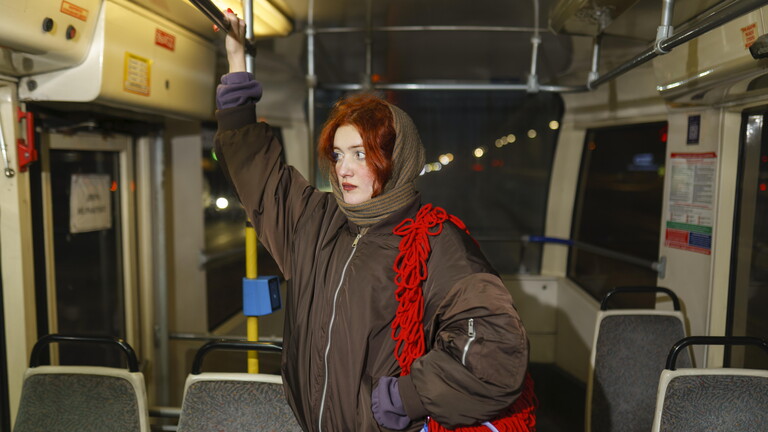 Eine Frau steht alleine in einer Bahn