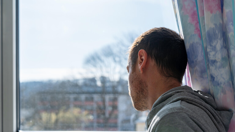 Ein Mann schaut aus dem Fenster