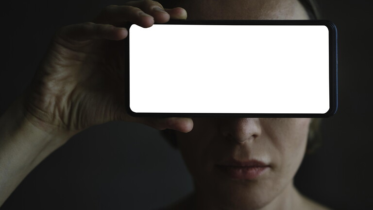 Frau hält sich Smartphone vor Augen