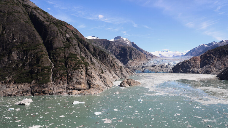 Blick auf das Tracy Arm Fjord in Alaska. Berge ragen in die Höhe, Wasser mit Eis und im Hintergrund ein Gletscher. Hier soll sich im Sommer 2025 ein Tsunami ereignet haben.