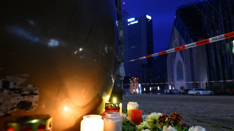 In der Innenstadt von Leipzig liegen Kerzen und Blumen nach der mutmaßlichen Amokfahrt. Im Hintergrund ist Absperrband der Polizei erkennbar. (4.5.2026)