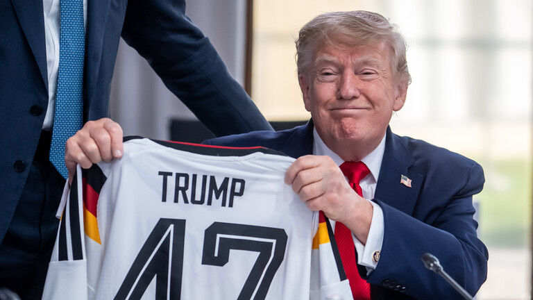 US-Präsident Donald Trump hält ein DFB-Fußball-Trikot mit dem Namen Trump und der Rückennummer 47, das er vom deutschen Kanzler Friedrich Merz bei einem Treffen der G7 bekommen hat (Evian, Frankreich, 16.06.2026)