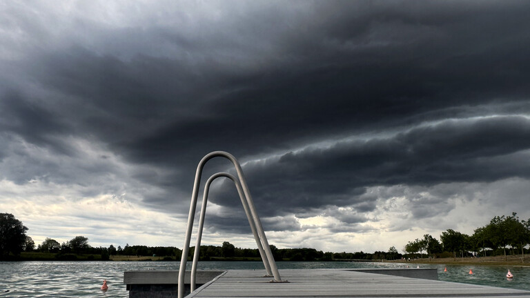 Dunkle Wolken über Steg und Leiter am Riemer See