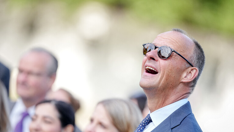 Bundeskanzler Friedrich Merz (CDU) lachend mit Sonnenbrille in Himmel schauend