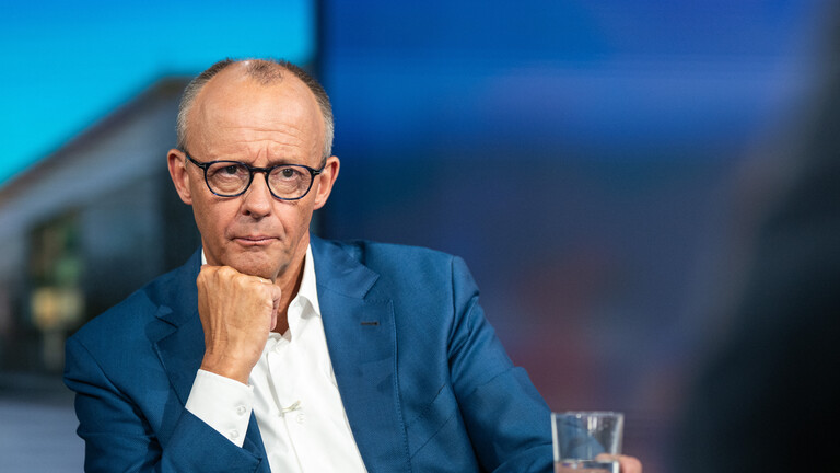Bundeskanzler Friedrich Merz in einem TV-Studio mit Wasserglas