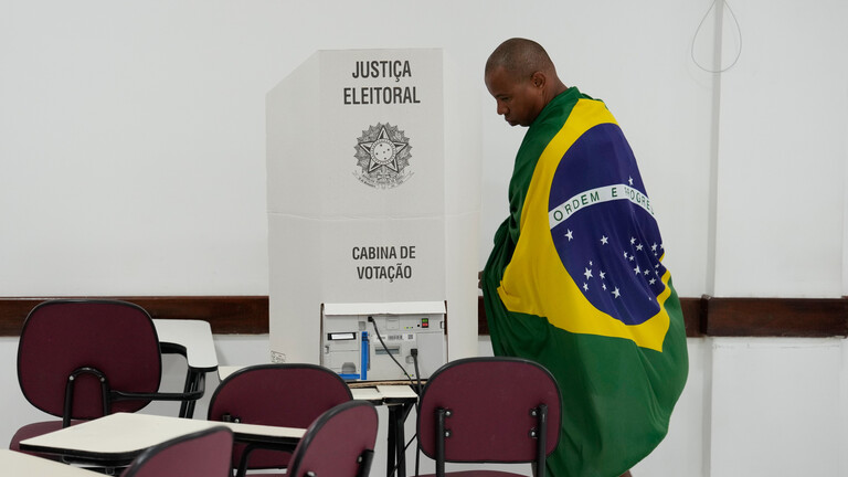 Ein Wähler, gehüllt in die brasilianische Flagge, bei den Präsidentschaftswahlen am 4.10.2026 in Brasilia, Brasilien