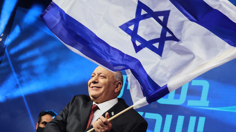 Der ehemalige israelische Generalstabschef und Vorsitzende der Yashar-Partei, Gadi Eisenkot, schwenkt am 28.10.2026 auf der Bühne im Parteihauptquartier in Tel Aviv die israelische Flagge, nachdem die ersten Ergebnisse der Nachwahlbefragungen zur israelischen Parlamentswahl bekannt gegeben wurden.