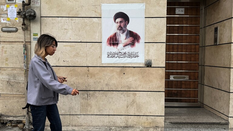 Eine Frau geht an einem Plakat vorbei, dass Mojtaba Khamenei zeigt, Irans neuen Obersten Führer, aufgenommen in Tehran am 13, April 2026