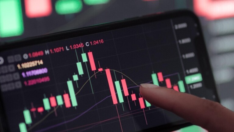 Verlauf eines Aktienkurses auf großem Bildschirm und auf einem Smartphone