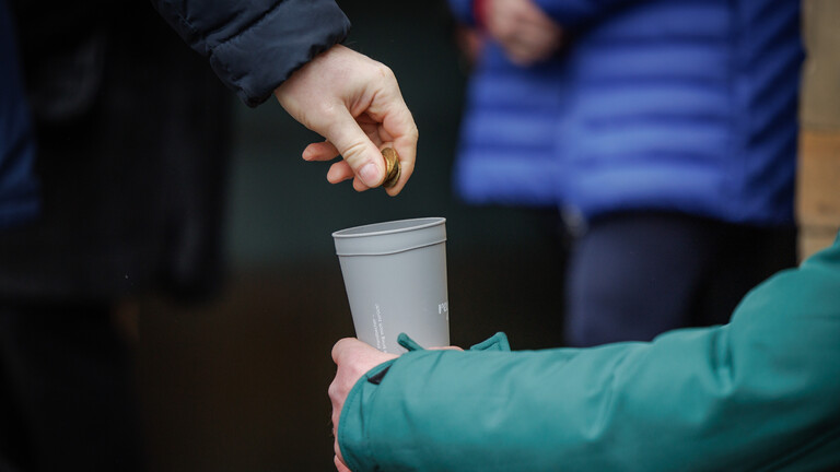 Ein Mann spendet Bargeld vor einer Kirche.