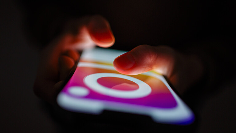 Kinderhände berühren das leuchtende Display eines Smartphones