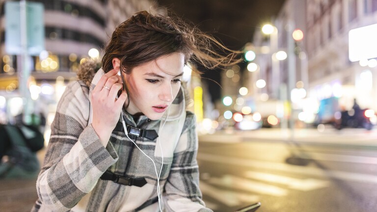 Eine junge Frau hält ein Smartphone in der Hand