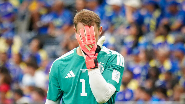 Der Torhüter der deutschen Nationalmannschaft, Manuel Neuer, hält sich einen Handschuh vor das Gesicht