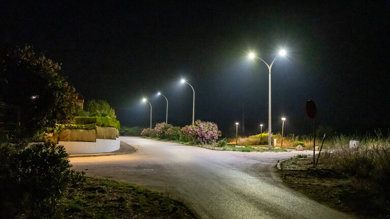 Helle Straßenlaternen an einer Straße bei Nacht.